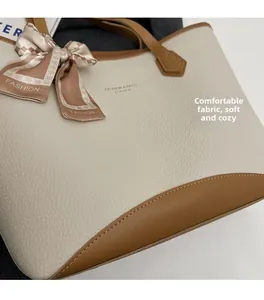 Close-up of litchi leather tote bag with elegant plaid scarf detail on handle