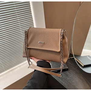 Close-up of brown corduroy tote bag featuring silver chain strap and metallic detail