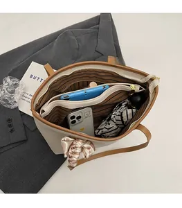 Detail view of large tote bag interior showing striped lining and zipper compartment