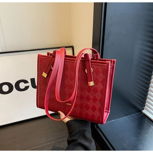 Detail of red quilted tote wedding bag with gold buckle and dual strap design
