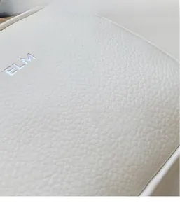 Close-up of white litchi grain leather texture and YELM metal logo on small round bag