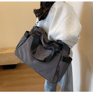 Vue latérale du grand sac de voyage gris anthracite en tissu oxford porté en bandoulière