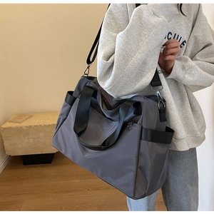 Détail du sac de voyage gris en oxford avec poignées et bandoulière réglable pratique