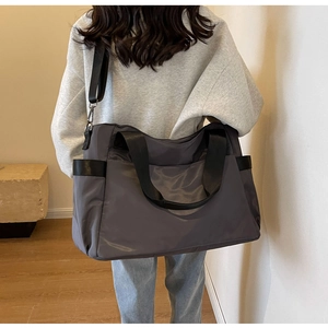 Détail du sac de voyage en nylon haute capacité avec anses noires et poche latérale
