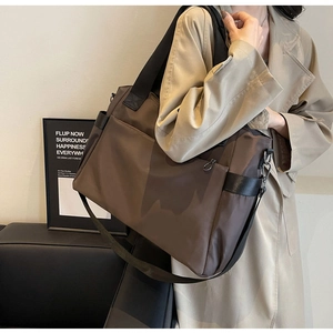 Détail d'un grand sac de voyage Oxford marron foncé avec de larges anses en toile noire