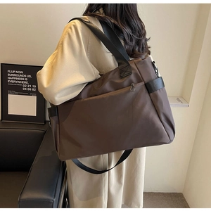Détail macro du grand sac de voyage en nylon marron foncé avec poignées en cuir