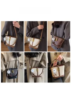 Detail view of the elegant leather bucket bag featuring a secure golden metal rotating buckle