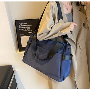 Détail du sac de voyage bleu en oxford avec larges sangles en nylon et poches latérales