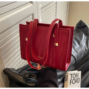 Detailed view of red tote bag with wavy texture and gold Shiyinman brand logo