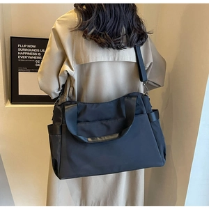 Détail de la vue arrière d'un grand sac de voyage noir en tissu Oxford avec bandoulière