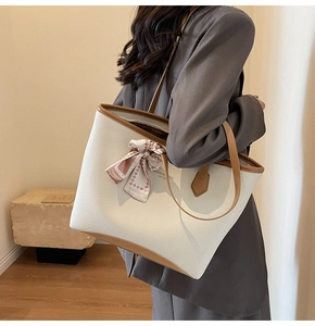 Detailed side view of white lychee leather tote bag with silk scarf and brown trim