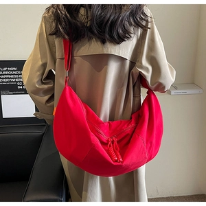 Detail of red crescent nylon crossbody bag with adjustable strap and rope zipper pull