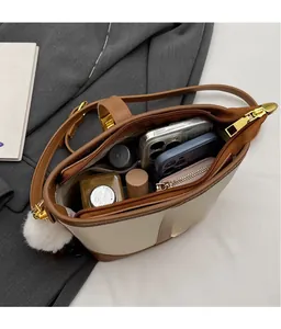 Top view of the two-tone bucket bag showing large interior space and various accessories