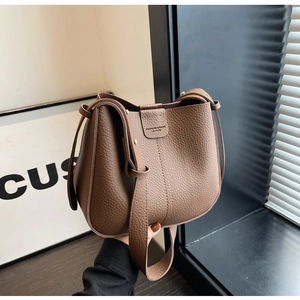 Détail de la texture cuir grainé et du logo embossé sur le sac seau marron foncé