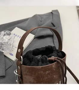 Détail du sac seau marron vintage avec boucles argentées et fermeture à cordon
