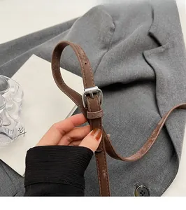 Gros plan de la bandoulière réglable en cuir marron avec boucle en métal argenté