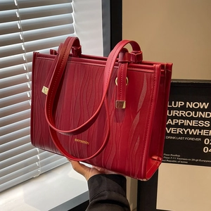Elegant red wedding tote bag with vertical wave texture and gold handles