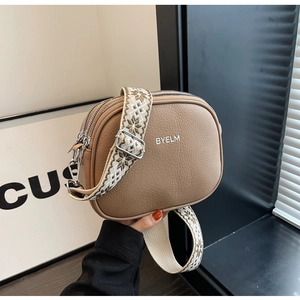 Detail of khaki pebbled leather camera bag with jacquard woven wide shoulder strap