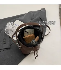 Vue de dessus de l'intérieur spacieux du sac seau en cuir marron avec doublure à cordon