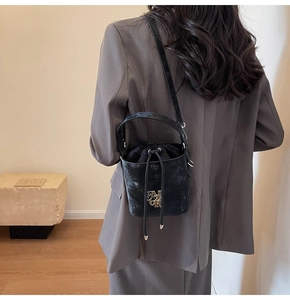Détail d'un sac seau noir avec cordon de serrage, logo NR et finition en velours