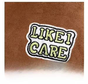 Detail of brown faux suede fabric featuring a LIKE I CARE embroidered patch on a tote bag