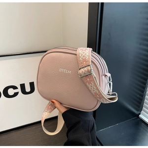 Detail of pink pebbled leather crossbody bag with ethnic embroidered wide strap