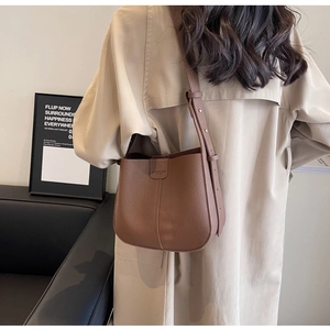 Détails du sac seau en cuir marron avec texture grainée et bandoulière réglable