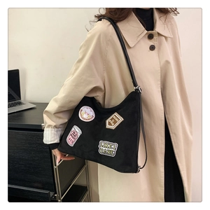 Detail of black tote bag with vintage embroidery patches for daily office commute