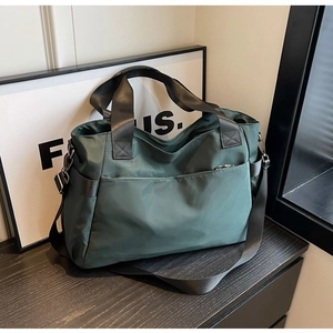 Détail du sac de voyage en nylon imperméable vert foncé avec bretelles noires réglables
