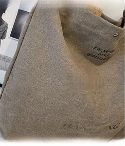 Close-up of thick canvas tote bag showing weave texture and side branding details