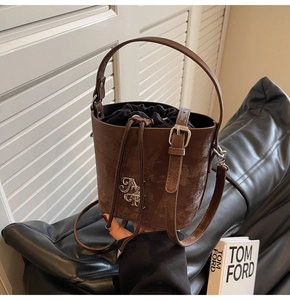 Gros plan sur un sac seau en cuir marron vintage avec logo et doublure à cordon
