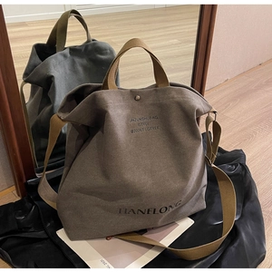 Close-up of deep brown canvas tote bag with adjustable shoulder strap and vintage texture