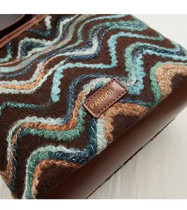 Macro view of retro bucket bag with colorful wavy embroidery and PANDOLA leather logo