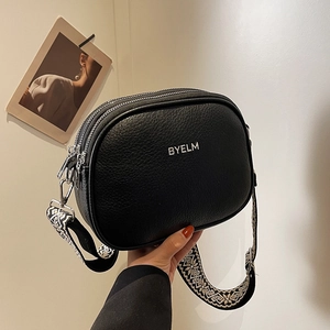 Fashionable black pebbled leather crossbody bag with ethnic style wide strap and dual zippers