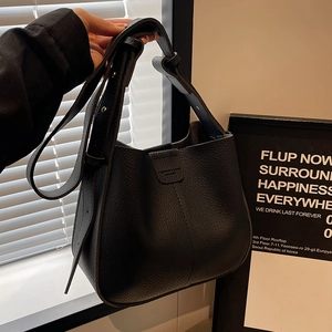 Sac seau rétro noir texture litchi avec bandoulière réglable sous un éclairage élégant