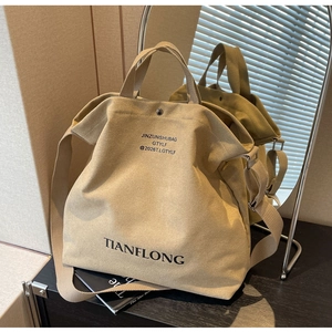 Detail of khaki canvas tote bag featuring magnetic metal buckle and adjustable shoulder strap
