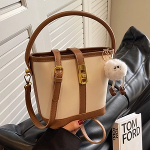 Women's vintage color-block bucket bag in cream and brown with plush ball charm