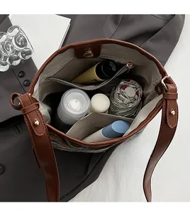 Interior view of brown leather bucket bag showing large capacity and multi-pocket layout