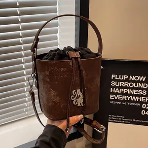 Sac Seau en Cuir PU Vintage pour Femmes Logo Métallique Usé Cordon de Serrage Bandoulière Sac à Main Rétro Voyage Quotidien
