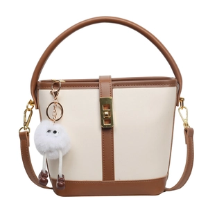 Two-tone bucket bag in cream and brown with top handle and cute plush charm