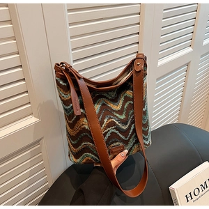 Detail of vintage bohemian knit bucket bag featuring retro wave patterns and leather strap