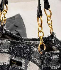 Dettaglio dell'anello in metallo dorato e del tessuto in tweed della borsa tote