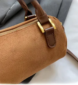 Detail of matte brown Boston bag showing frosted leather texture and gold metal zipper