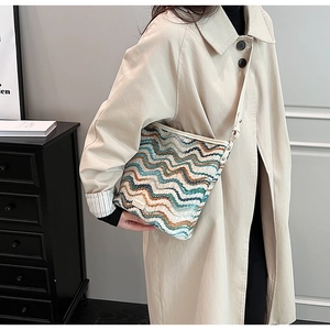 Detail of woven bucket bag featuring wave patterns and a premium brand label on the side