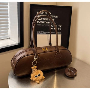 Detailed macro view of vintage brown bowling bag with twin gold zippers on a metal table