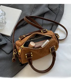 Interior view showing phone and lipstick in brown matte Boston bag with top handles