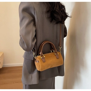 Brown frosted Boston bag featuring a vintage cylinder design and golden hardware details