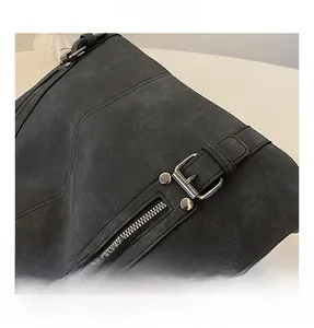 Détails d'un sac cabas noir mat avec boucle en métal argenté et coutures de style vintage