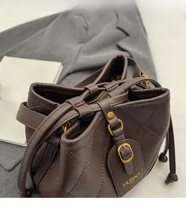 Détail du sac seau en cuir café montrant le matelassage et la fermeture à cordon