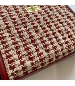 Detail of red and white tweed wedding bag with diamond quilting and gold metal lock